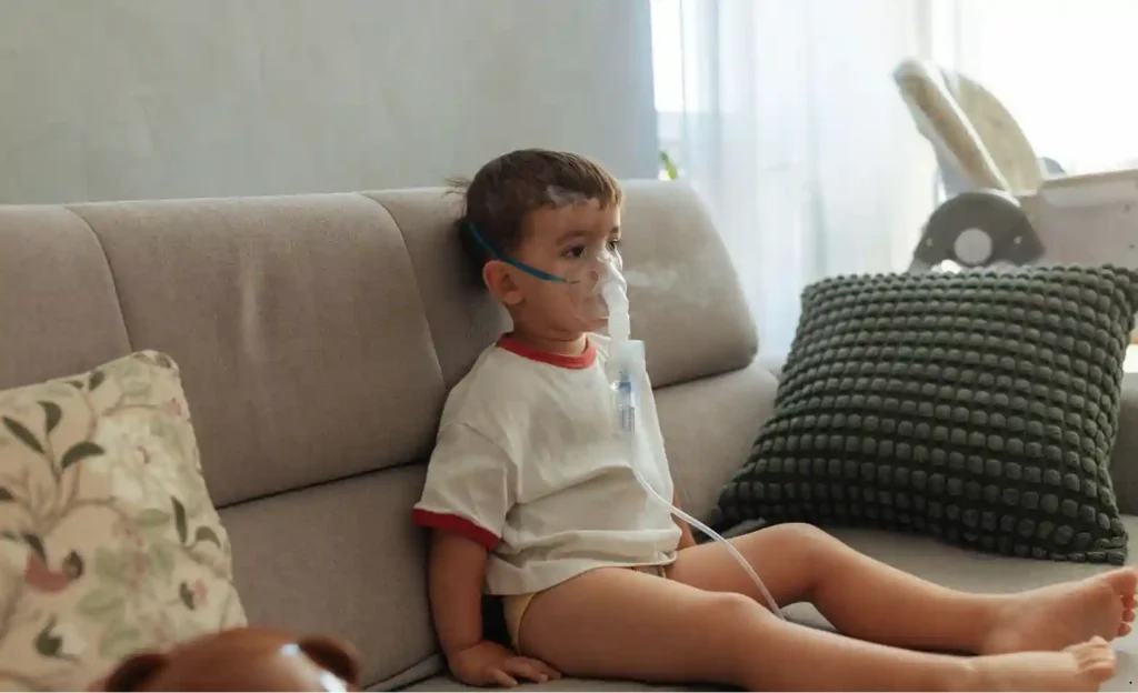 Child with asthma using a nebulizer at home due to poor indoor air quality from dirty air ducts